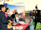 Volunteers at a table handing out candy and info to a trunk or treater